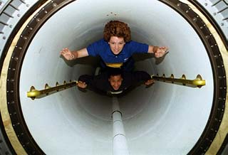 Pilot Eileen Collins (top) and mission specialist Ed Lu float through Spacehab's transfer tunnel.